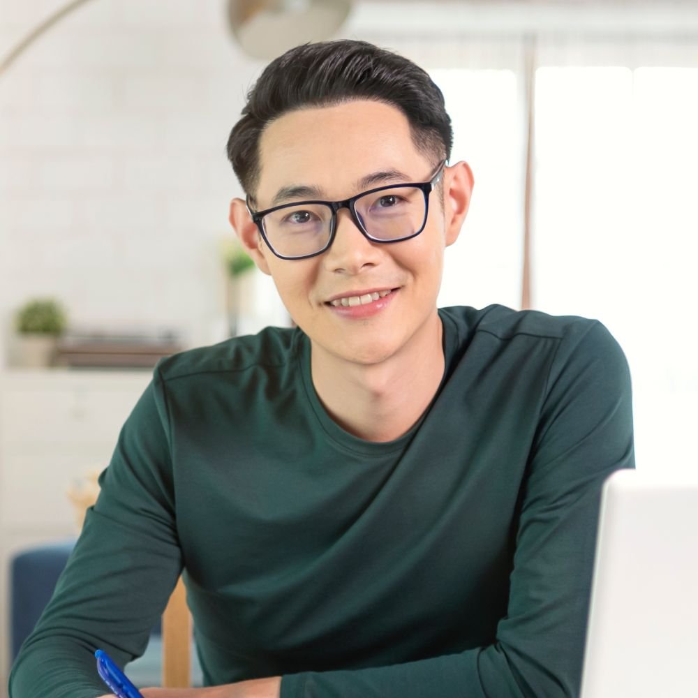 Smiling Handsome Asian Businessman Working From Ho VGXEJQQ 1